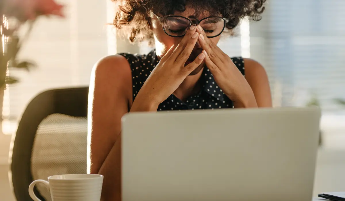 Jeune femme stressée devant un ordinateur portable