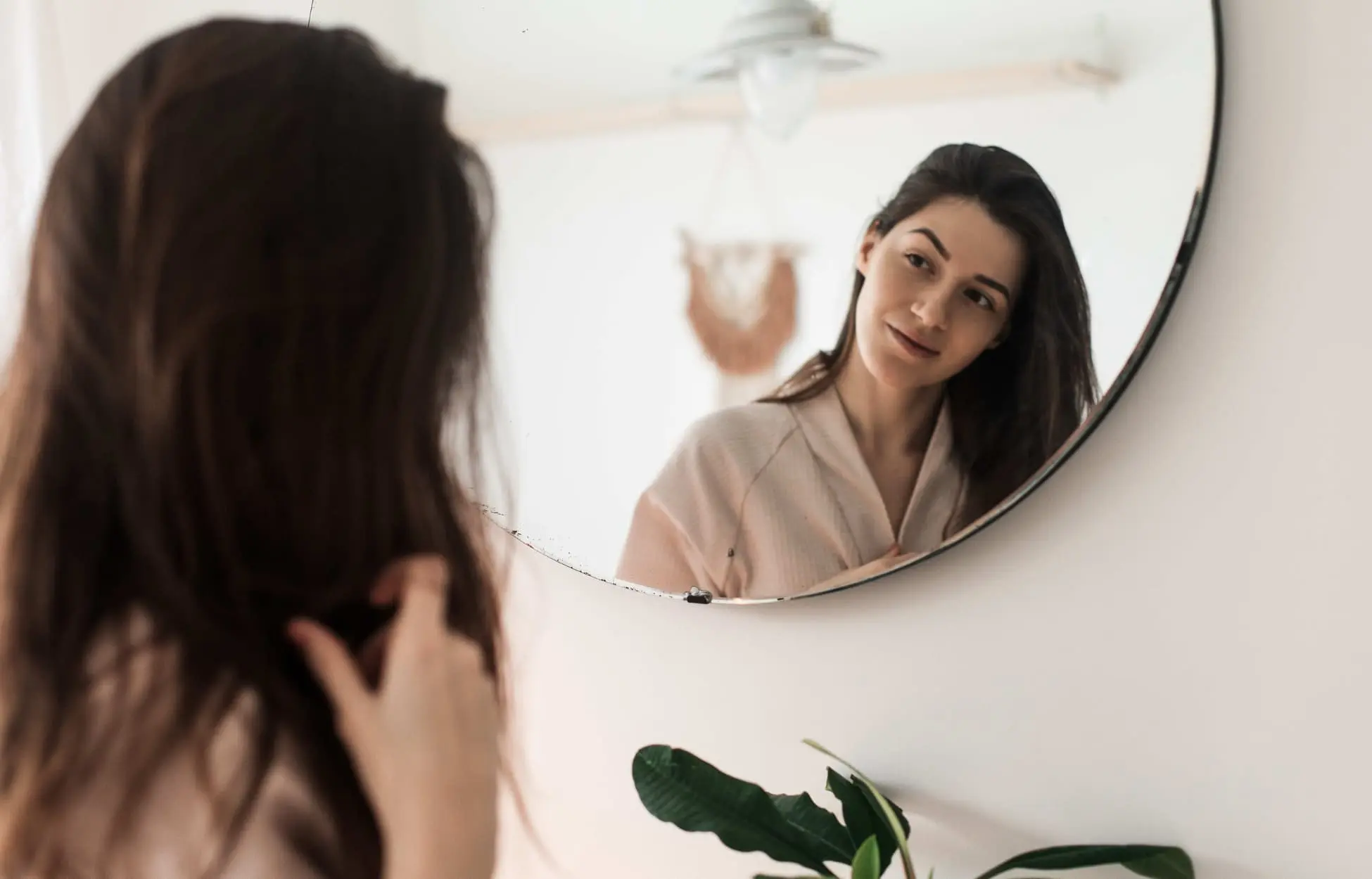 jeune femme devant son miroir en train de regarder ses rides d'expression